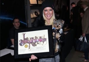 Image of Tara Reid holding her framed star gift for when she had a star named after her